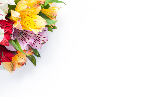 Bouquet of colorful flowers alstroemeria on white background. Flat lay. Horizontal. Mockup with copy space for greeting card, social media, flower delivery, Mother's day, Women's Day - Photo, image