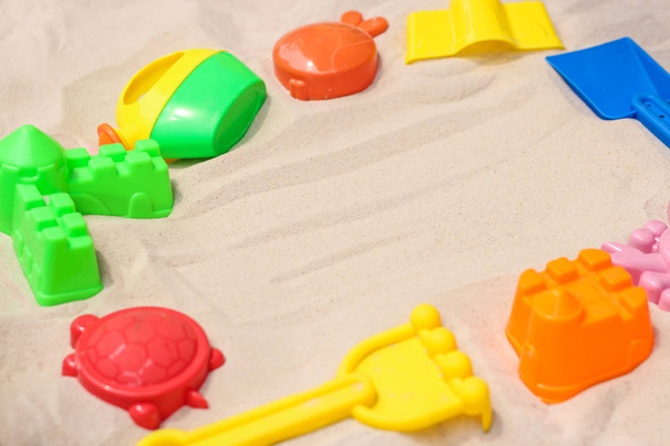 Φωτεινό πλαστικά παιδικά παιχνίδια στην άμμο. Έννοια του αναψυχή παραλία για τα παιδιά. Το top view. Χώρο για το κείμενο. Επίπεδη lay, top view, αντίγραφο χώρου - Φωτογραφία, εικόνα