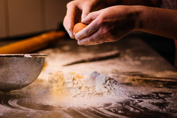 El chef mezcla la masa de harina y huevos. Harina de humo Siftin
 - Foto, Imagen