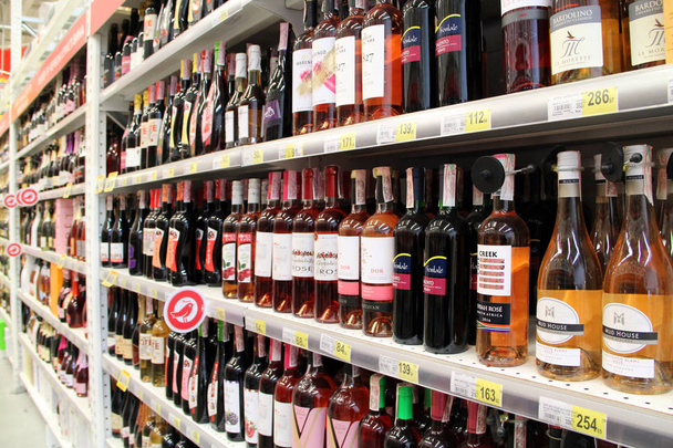 Wine shop with wide choise. Alcoholic drinks on shelves of supermarket - Photo, Image