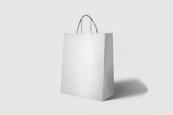 Τσάντα για ψώνια για διαφήμιση και επωνυμία. Λευκή χάρτινη σακούλα, κουτί με κενά σκάφη σε απαλό γκρι φόντο. - Φωτογραφία, εικόνα