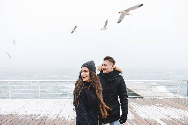 Young happy loving couple walking at the beach outdoors. - Zdjęcie, obraz