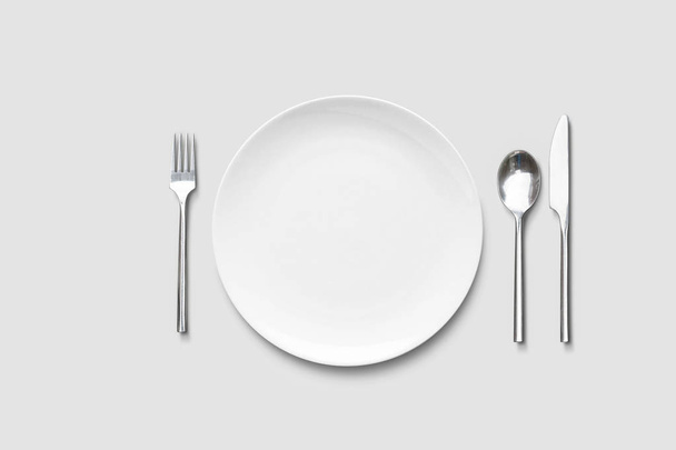 Table place, reserve card, menu mockup on a soft gray background.Plate with spoon and fork. - Foto, afbeelding