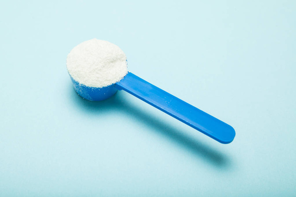 Milk powder in a measuring spoon. - Foto, Imagen