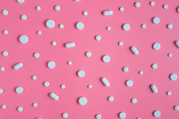 pílulas brancas em fundo rosa.  - Foto, Imagem