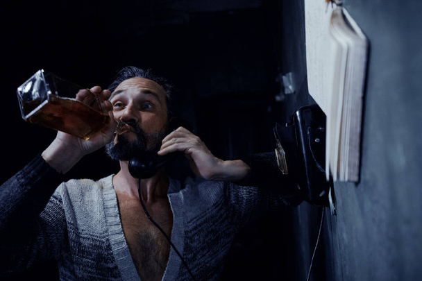A Brutal Alcoholic Calls At An Old Phone and Laughs At Someone. - Fotografie, Obrázek