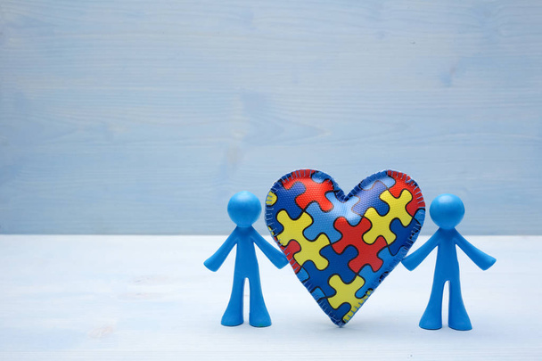 doll children background with symbolic autism puzzle heart - Foto, Bild