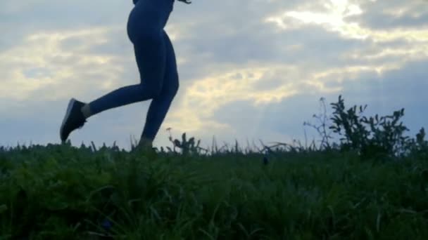 Αργή κίνηση Close Up, γυναικεία running σε υπόβαθρο σιλουέτα Ανατολή του ηλίου. Κορίτσι τζόκινγκ πλάγια όψη, παρακολούθηση πλάνο κοντινό στο golden sunrise - Πλάνα, βίντεο