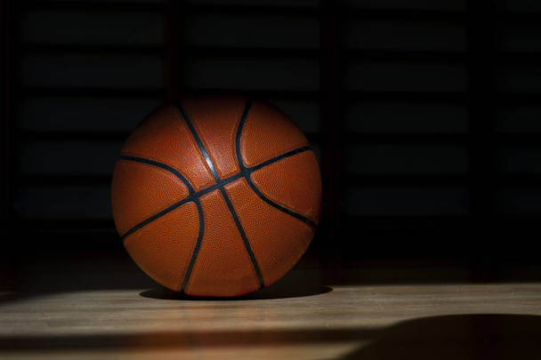 Balle de basket sur le parquet avec fond noir
 - Photo, image