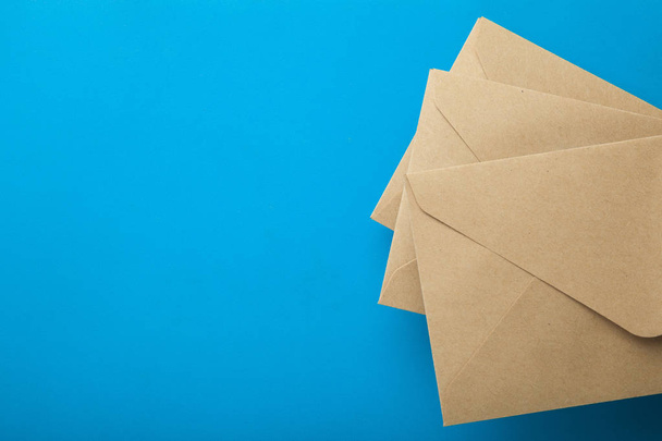 Three envelopes of recycled paper on a blue background, empty sp - Photo, image