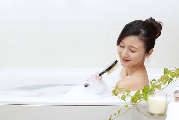 schöne junge Frau nimmt ein entspannendes Bad - Foto, Bild