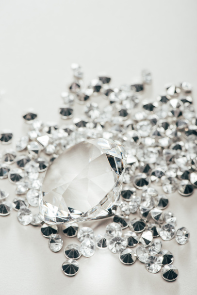 selective focus of transparent pure big diamond among small on white background - Foto, imagen