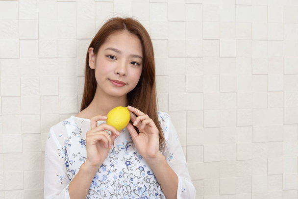 Portrait de jeune femme avec un citron dans les mains
 - Photo, image
