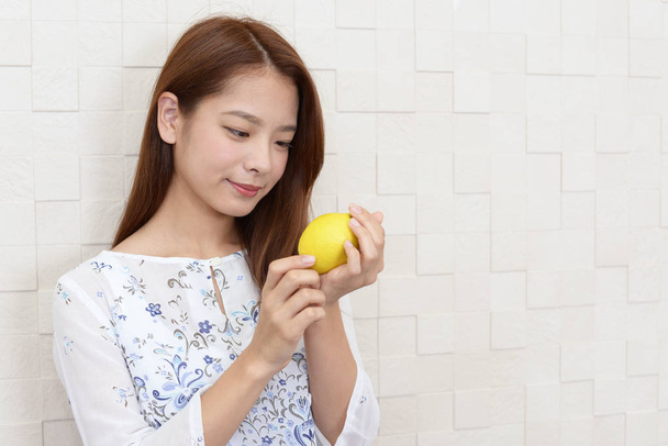 Retrato de mujer joven con un limón en las manos
 - Foto, imagen