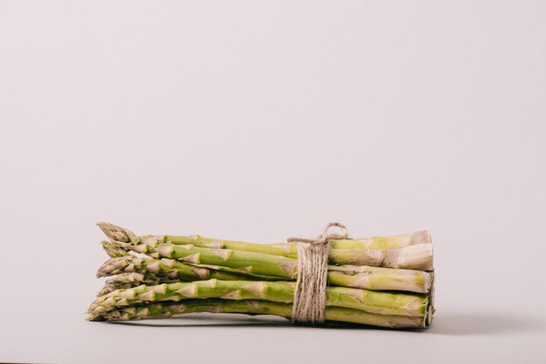 bunch of green asparagus tied with rope on grey background - Fotografie, Obrázek