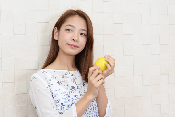 Portré, fiatal nő, kezében a citrom - Fotó, kép