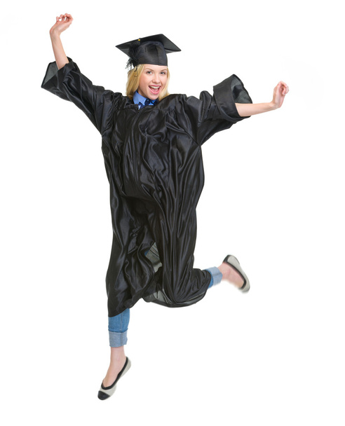 Full length portrait of young woman in graduation gown jumping - Φωτογραφία, εικόνα
