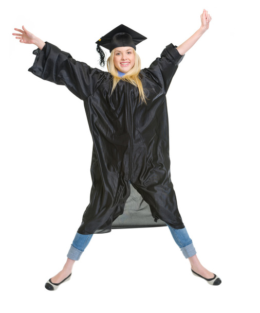Full length portrait of smiling young woman in graduation gown j - 写真・画像