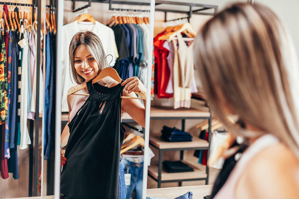 Young woman shopping in clothing store - Valokuva, kuva