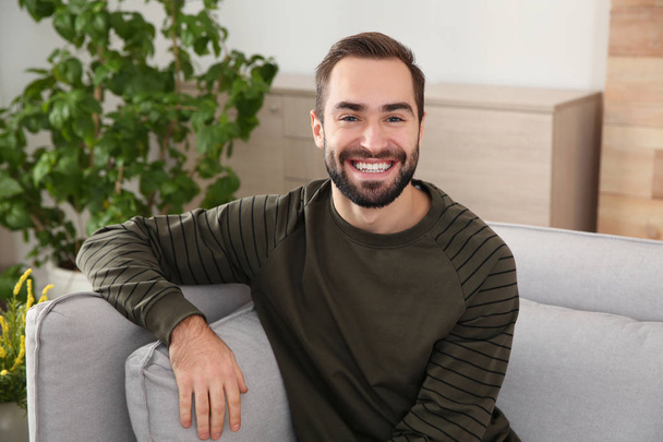 Portrait of young man laughing at home - Photo, image