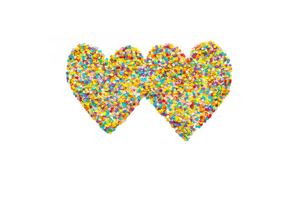 Heart made of colored confetti. Small circles of colored paper. White background. View from above. Colored heart. - Foto, immagini