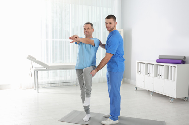 Doctor working with patient in hospital. Rehabilitation exercises - Foto, imagen