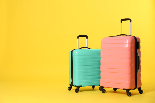 Stylish suitcases on color background. Space for text - Fotó, kép