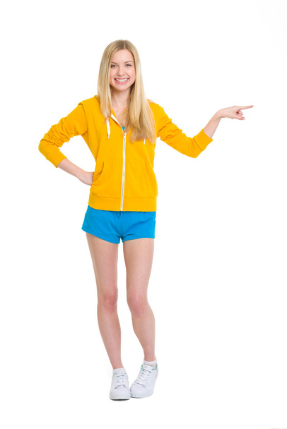 Full length portrait of happy teenager girl pointing on copy spa - Foto, immagini