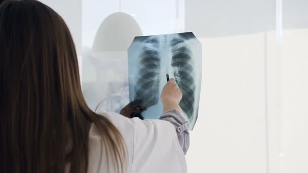 Young female and male doctors discussing xray prints of patient in the hospital. - Filmagem, Vídeo