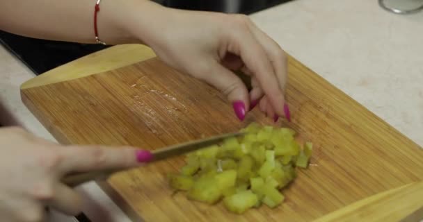 Žena v domácnosti ruce krájení nakládané okurky na kousky v kuchyni - Záběry, video