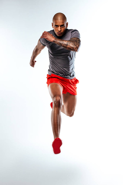 Runner wearing sportsuit demonstrating his muscles power - Fotó, kép