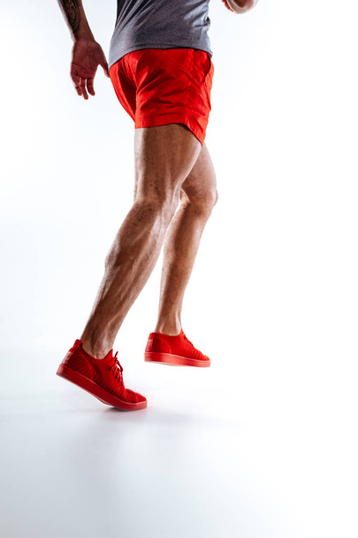 Mans figure wearing red shorts performing running movements - Foto, afbeelding