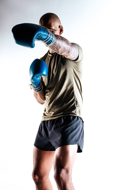 Young man wearing boxing gloves doing boxing movements - Foto, Bild