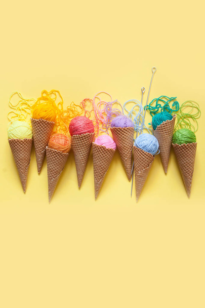 Balls of yarn lie in a waffle cone for ice cream. Coloured wool. - Photo, Image