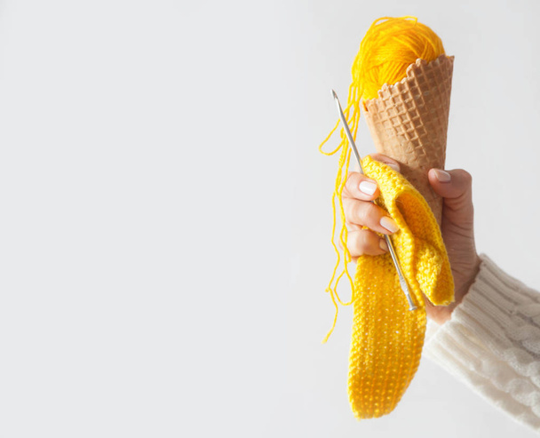 Balls of yarn lie in a waffle cone for ice cream. Coloured wool. - Fotoğraf, Görsel