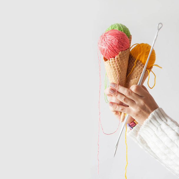 Balls of yarn lie in a waffle cone for ice cream. Coloured wool. - Valokuva, kuva