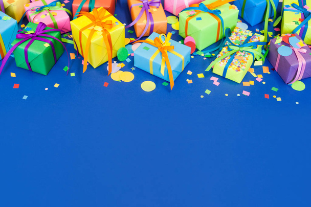 Colored holiday gifts. Blue background. - Foto, afbeelding