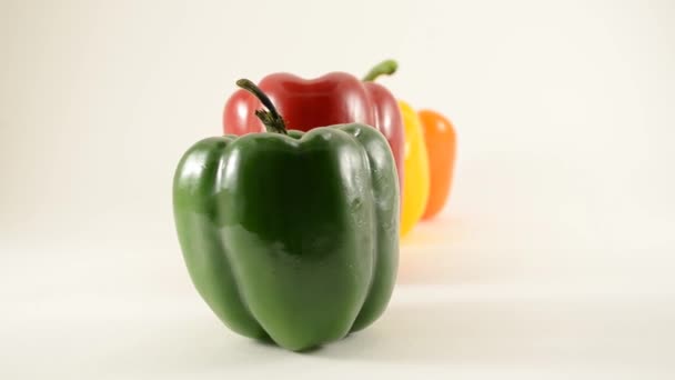 Green, Red, Yellow and Orange Peppers Against White - Line Arrangement - Dolly Left - Footage, Video