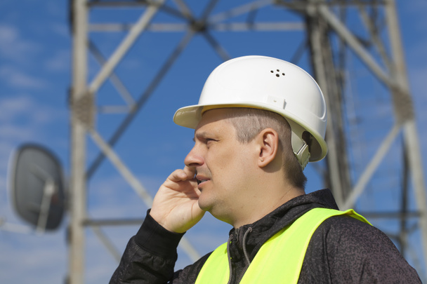 Mérnök, közel a gsm tower mobiltelefonon beszél - Fotó, kép