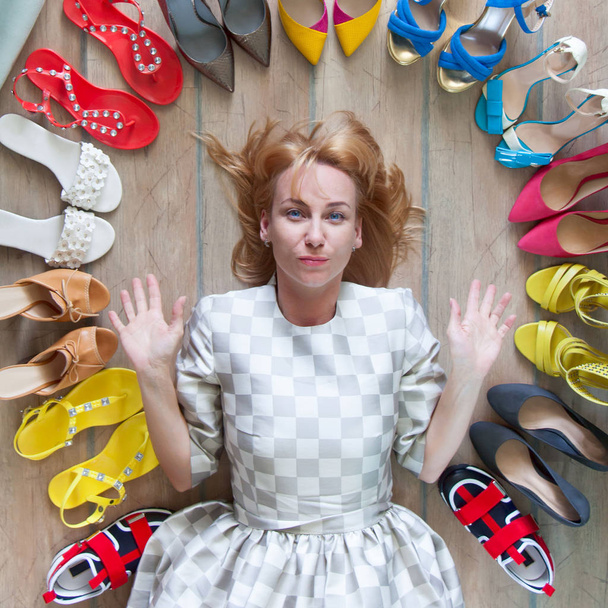 Kobieta wybierająca buty. Kolorowe buty są odsłonięte w kole. - Zdjęcie, obraz