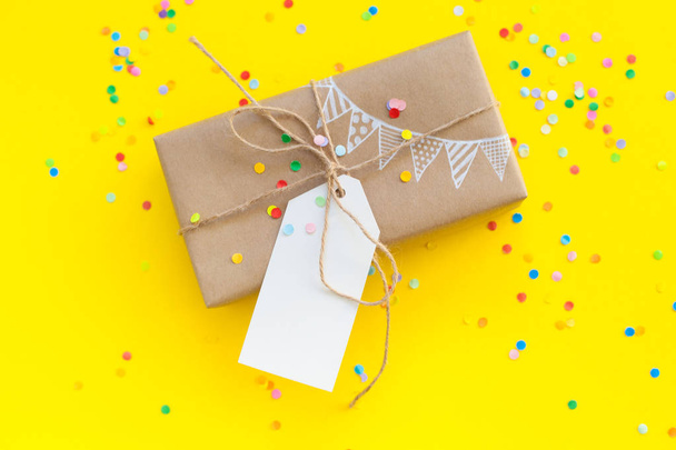 Colored gift boxes with jute rope. Yellow background. Gifts for party or a birthday. - 写真・画像