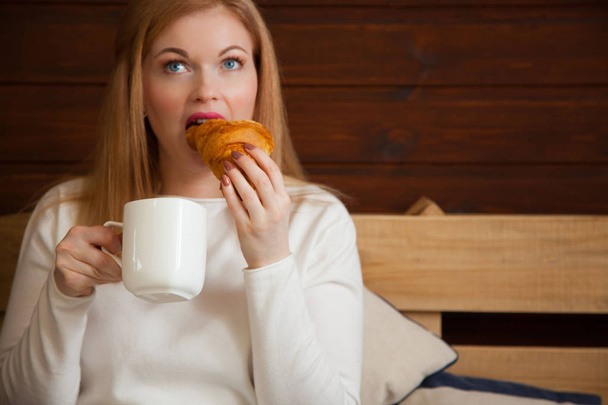 A woman drinks tea and has croissants with jam. Frozen bun. - Fotografie, Obrázek