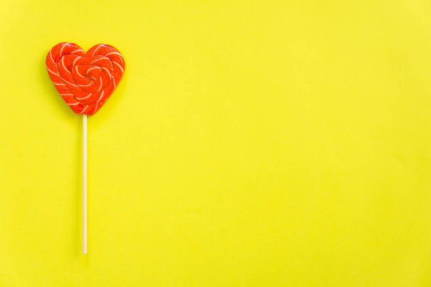 Red lollipop. Candy in the form of heart. - Photo, image