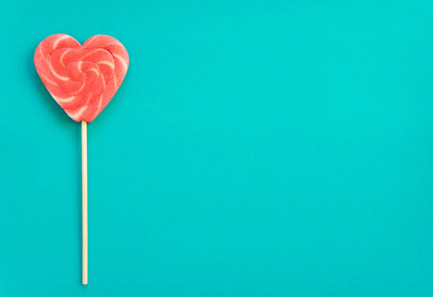 Red lollipop. Candy in the form of heart. - Zdjęcie, obraz
