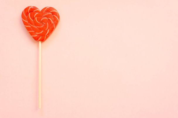 Red lollipop. Candy in the form of heart. - Фото, изображение