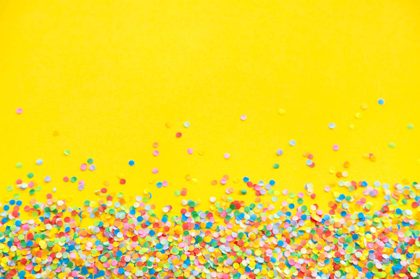 Frame made of colored confetti. Yellow background - Fotó, kép
