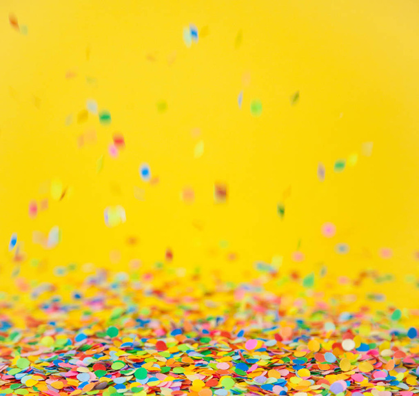 Kolorowy konfetti Latanie na żółtym tle - Zdjęcie, obraz
