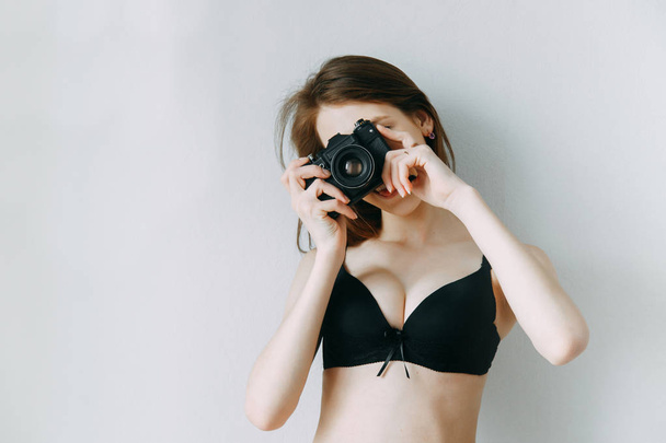 Girl in lingerie with a camera in his hands. Blogger on the cover of an advertising poster. - Fotó, kép