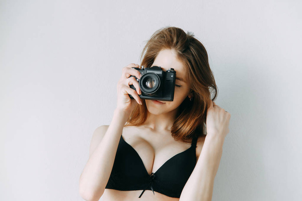 Girl in lingerie with a camera in his hands. Blogger on the cover of an advertising poster. - Фото, зображення