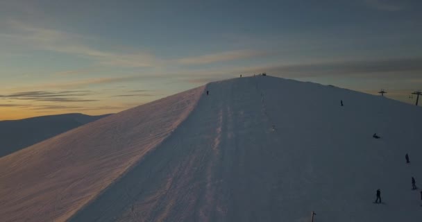 Luftaufnahme von Menschen beim Snowboarden bei Sonnenuntergang  - Filmmaterial, Video